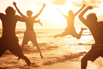 group of young people jumping at the beach