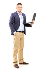 Naklejka na ściany i meble Full length portrait of a man holding a laptop