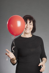 Frau mit rotem Ballon lachend