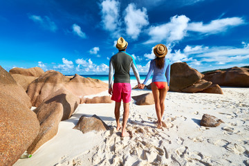 Fototapeta premium Couple at tropical beach wearing rash guard