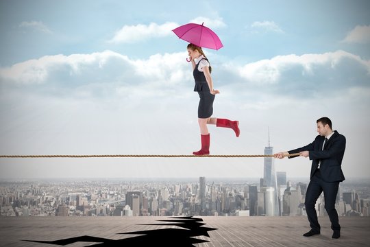 Young Business Man Pulling A Tightrope For Businesswoman