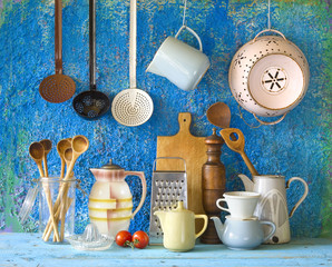 various vintage kitchen utensils,against blue wall