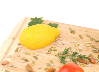 Closeup of lemon and nuts on cutting board.