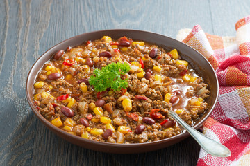 Mexican dish chili con carne in a brown pottery plate