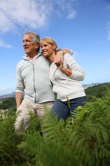 Senior couple walking in countryside, scenery