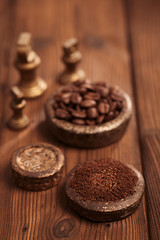 grated coffee in old iron weights and wooden  background