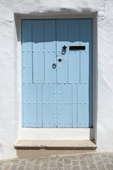 wooden blue door and whitewashed wall © chrupka
