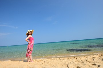 一人で楽園を旅行しているピンクの服の女性