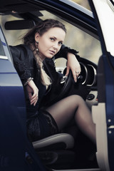 Naklejka na ściany i meble Fashion woman sitting in a car