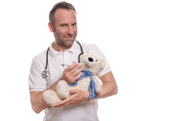 Lächelnder Kinderarzt mit einem Teddybären misst Fieber