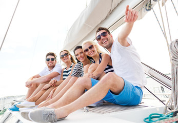 smiling friends sitting on yacht deck