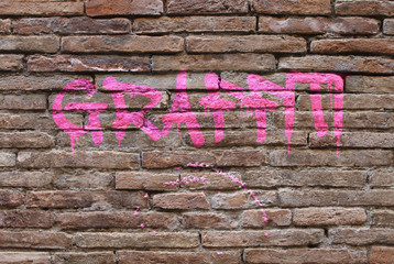 Muro a mattoncini con scritta rosa Graffiti e chewing gum
