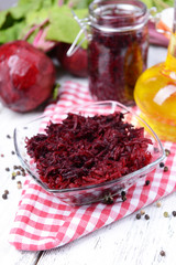 Grated beetroots in bowl on table close-up