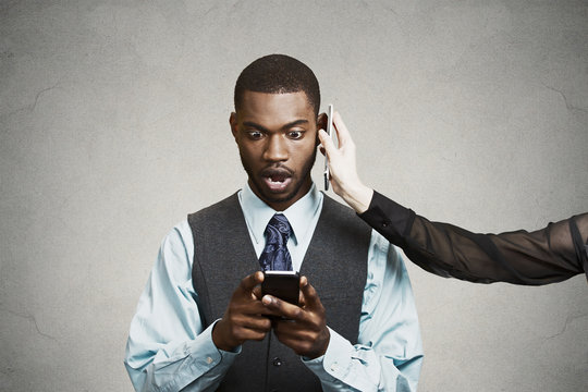 Shocked businessman reading bad news on smart phone