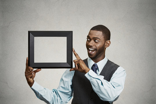 Happy businessman holding empty picture frame open to new ideas