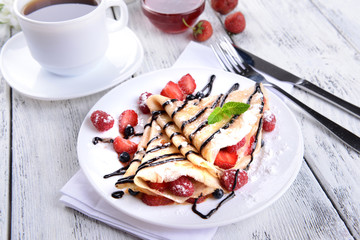 Delicious pancakes with berries on table close-up
