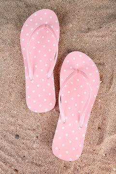 Color flip-flops on sand background