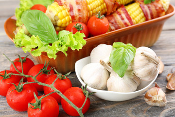 Grilled bacon wrapped corn on table, close-up