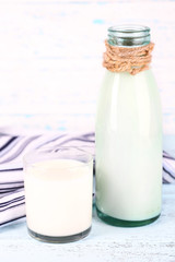 Glass bottle of milk on wooden background