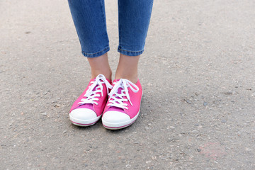 Pink sneakers on girl legs outdoors