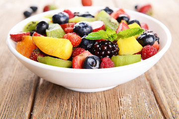 Delicious fruits salad in plate on table close-up