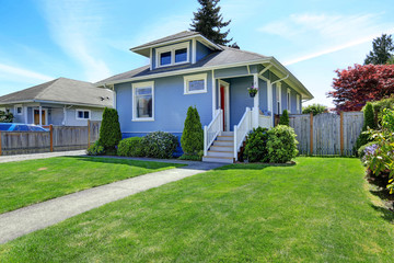 House exterior in light blue. View of front yard and entrance po