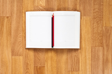 Blank notepad with office supplies on wooden table.