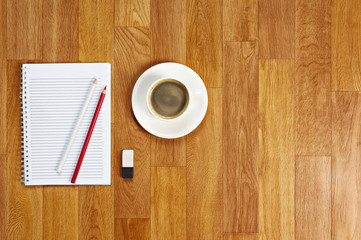 Blank notepad with office supplies and cup of coffee on wooden t