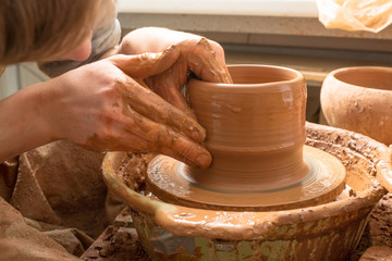 hands of a potter, creating an earthen jar