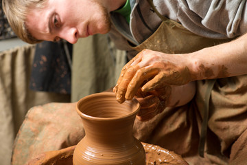 hands of a potter, creating an earthen jar