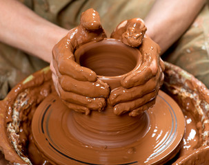 hands of a potter, creating an earthen jar