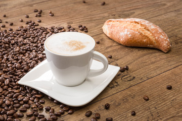 Tasse Cappuccino mit Bagutette und Kaffeebohnen