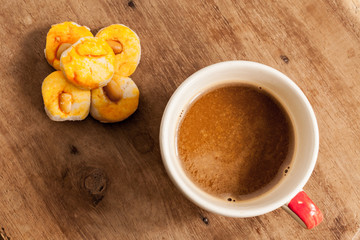 coffee cup with cookie on wood table.