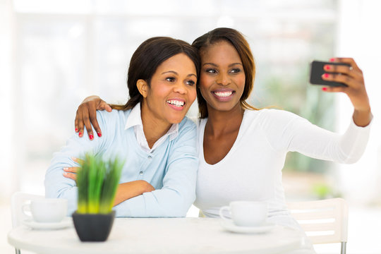 middle aged african mother and daughter taking self portrait