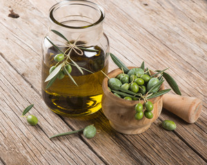 olive oil and freshly harvested olives in mortar