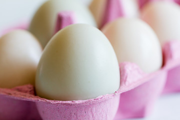 Mixed duck eggs in pink egg box