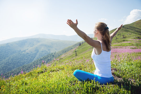 Young woman meditate on the top of mountain
