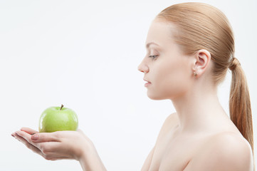 Portrait of young attractive woman holding a green apple