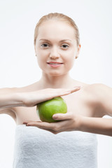 Portrait of young attractive woman holding a green apple