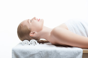 Young beautiful woman in spa relaxing on massage table