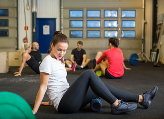 Fototapeta na wymiar Woman Doing Relaxation Exercise In Crossfit Gym
