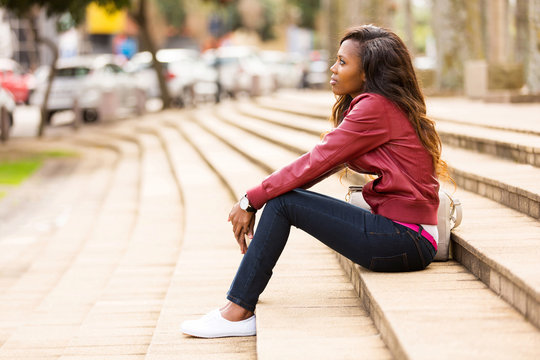 young african woman sitting outdoors
