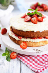 Delicious biscuit cake with strawberries on table close-up