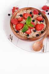 Tasty oatmeal with berries isolated on white