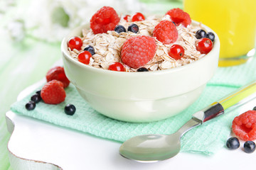 Tasty oatmeal with berries on table close-up