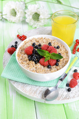 Tasty oatmeal with berries on table close-up