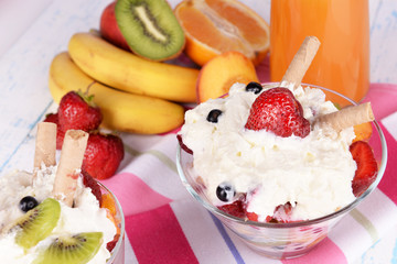 Fresh fruits salad with ice cream in bowl and juice