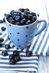 Delicious blueberries in cup on table close-up