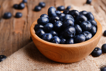 Delicious blueberries in bowl on table close-up