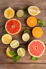 Naklejka na ściany i meble Different sliced juicy citrus fruits on wooden table